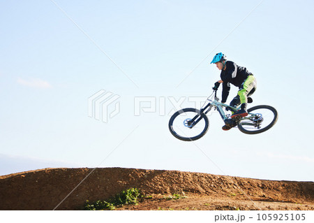 Cycling, sports and man jump with bicycle for adrenaline on adventure, freedom and in air for speed. Mountain bike, tricks and cyclist for training, exercise and fitness on dirt road, trail and track 105925105