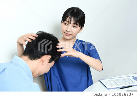 薄毛治療の診断をする医師と男性患者 105926237
