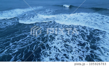 Drone shot of nordic ocean coastline with black sand beaches, icelandic natural scenery. Majestic atlantic shore landscape in iceland with snowy mountains and freezing cold water. Slow motion. Drone shot of nordic ocean coastline with black sand beaches, icelandic natural scenery. Majestic atlantic shore landscape in iceland with snowy mountains and freezing cold water. Slow motion. 105926783