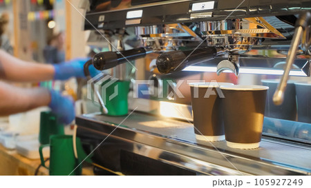 Closeup fresh espresso pours in two paper cups, espresso machine. Coffee culture and professional coffee making, service 105927249