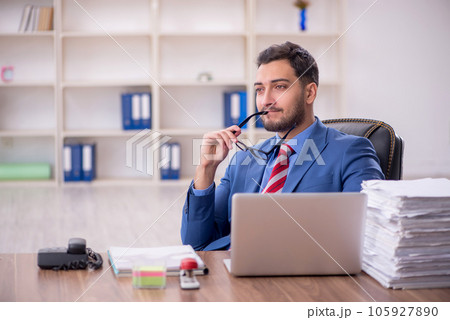 Young male employee unhappy with excessive work in the office 105927890
