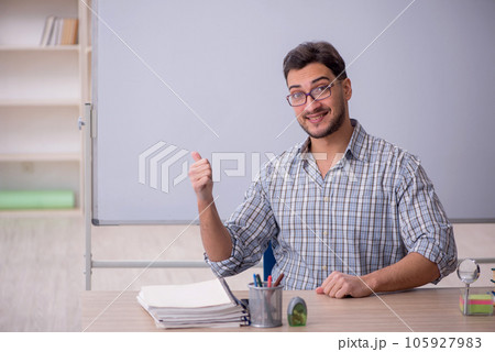 Young male teacher in front of white board 105927983
