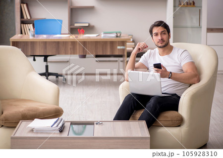 Young male employee working from home during pandemic Young male employee working from home during pandemic 105928310