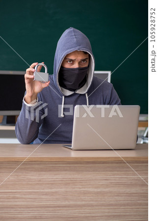 Young male hacker sitting in the classroom Young male hacker sitting in the classroom 105928752