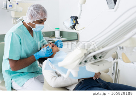 Male dentist treating female patient in dental clinic Male dentist treating female patient in dental clinic 105929189