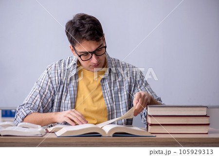 Young male student preparing for exams in the classroom Young male student preparing for exams in the classroom 105929313