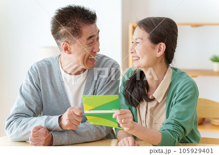 通帳を見て微笑むシニア夫婦 通帳を見て微笑むシニア夫婦 105929401