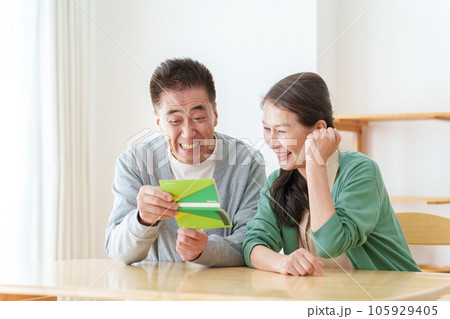 通帳を見て微笑むシニア夫婦 通帳を見て微笑むシニア夫婦 105929405