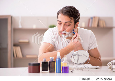 Young man shaving face at home Young man shaving face at home 105929598