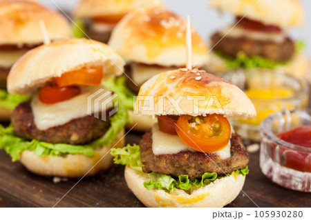 Ready to serve mini hamburgers. Step by step preparation of mini burgers. Homemade mini burgers for children or appetizers. Small hamburgers. 105930280
