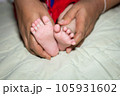 Mom caught the child's feet on the bed. 105931602