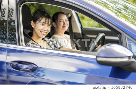 爽やかな夏に女性2人で車を運転して旅行に出かけるイメージ｜ドライブイメージ 105932746