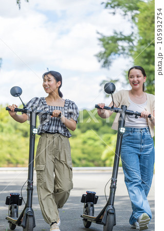 爽やかな夏空のもと電動キックボードで移動する若い女性|電動キックボードイメージ 爽やかな夏空のもと電動キックボードで移動する若い女性|電動キックボードイメージ 105932754