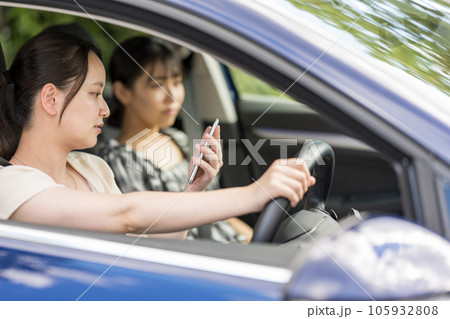 若い女性が運転中にスマートフォンを操作する危険運転イメージ|ながら運転イメージ 若い女性が運転中にスマートフォンを操作する危険運転イメージ|ながら運転イメージ 105932808