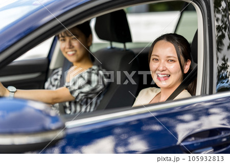 爽やかな夏に女性2人で車を運転して旅行に出かけるイメージ｜ドライブイメージ 105932813