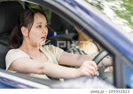 若い女性ドライバーが運転中に驚いた表情を見せるイメージ｜運転イメージ｜交通事故イメージ 105932823