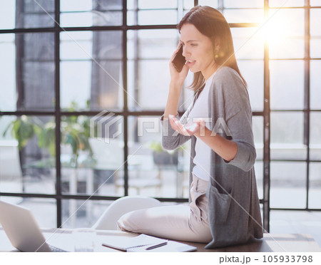 Businesswoman with phone in modern office talking 105933798