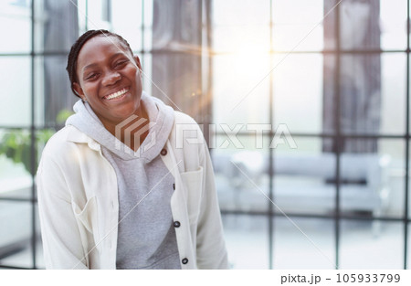 Smiling young woman standing and looking at the camera. Smiling young woman standing and looking at the camera. 105933799