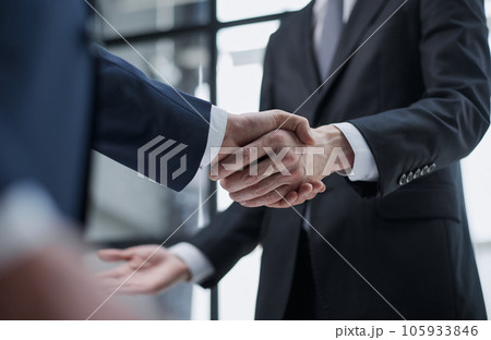 businessmen meeting and handshake in front of business center buildings businessmen meeting and handshake in front of business center buildings 105933846