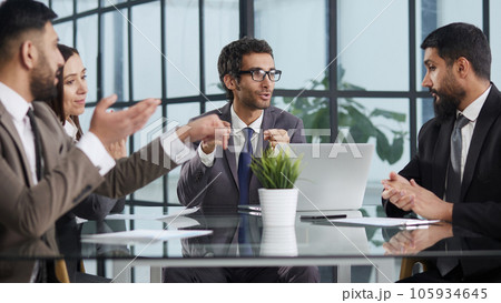 Glad to be part of the creative team. Group of cheerful business people sitting together at the table and discussing something 105934645