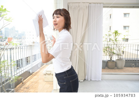 布巾で部屋の窓を拭く女性 布巾で部屋の窓を拭く女性 105934783