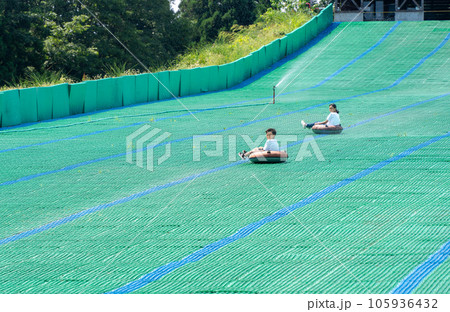夏休みに芝すべりで遊ぶアジア人の小学生 夏休みに芝すべりで遊ぶアジア人の小学生 105936432