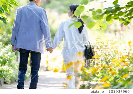 手を繋いで歩くカップル 105937960