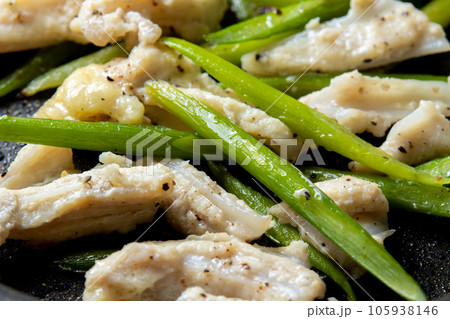 鶏軟骨(やげん軟骨)とにんにくの芽をフライパンで炒める調理シーン。 105938146