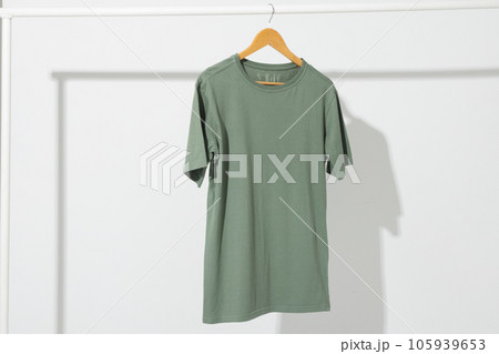 Green t shirt on hanger hanging from clothes rail with copy space on white background Green t shirt on hanger hanging from clothes rail with copy space on white background 105939653
