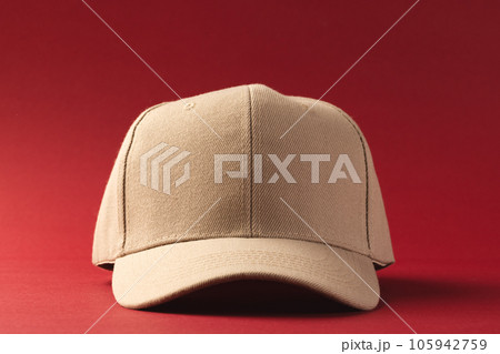 Cream baseball cap and copy space on red background 105942759