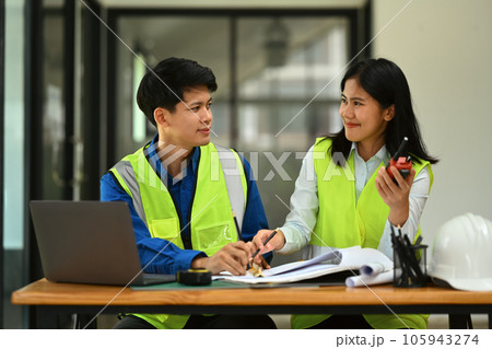 Architects man and woman working on blueprint and discussing the new project in office. Architects man and woman working on blueprint and discussing the new project in office. 105943274