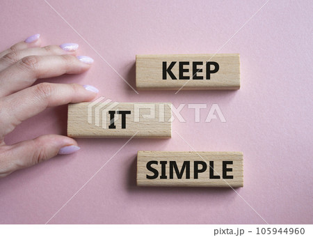 Keep it Simple symbol. Concept words Keep it Simple on wooden blocks. Businessman hand. Beautiful pink background. Business and Keep it Simple concept. Copy space. 105944960