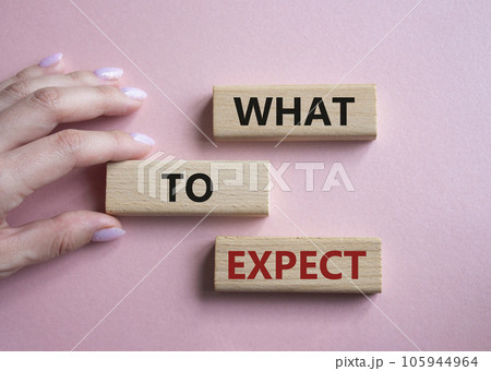 What to Expect symbol. Concept words What to Expect on wooden blocks. Businessman hand. Beautiful pink background. Business and What to Expect concept. Copy space. 105944964