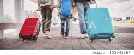 Mother, father and their son walking with suitcase to the airport. 105945164