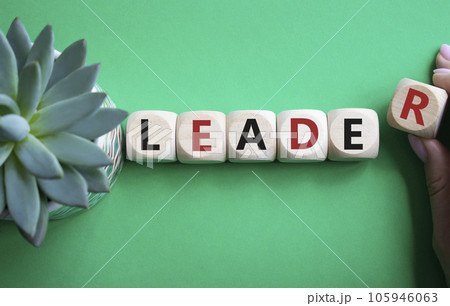 Leader symbol. Concept word Leader on wooden cubes. Businessman hand. Beautiful green background. Business and Leader concept. Copy space. 105946063