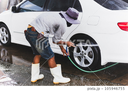 Unidentified man washing car on carwash station using high pressure water. 105946755