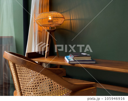 Table lamp with rattan shade on wooden table Table lamp with rattan shade on wooden table 105946916
