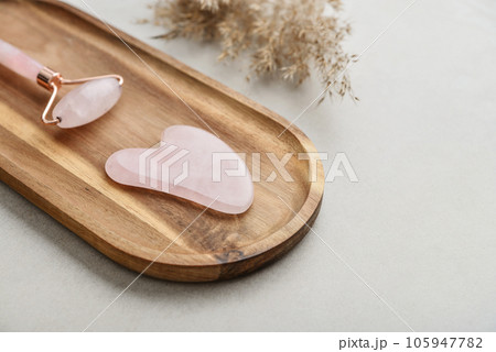 Facial rose quartz stone massage roller and gua sha massager 105947782
