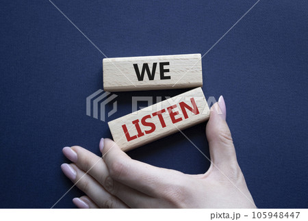 We listen symbol. Wooden blocks with words We listen. Businessman hand. Beautiful deep blue background. Business and We listen concept. Copy space. We listen symbol. Wooden blocks with words We listen. Businessman hand. Beautiful deep blue background. Business and We listen concept. Copy space. 105948447