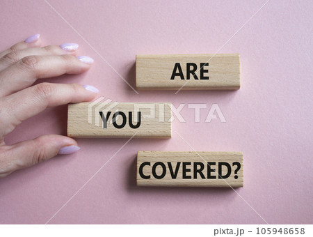 Are you covered symbol. Concept words Are you covered on wooden blocks. Businessman hand. Beautiful pink background. Business and Are you covered concept. Copy space. 105948658
