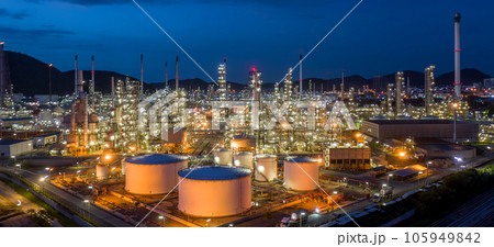 Aerial view oil and gas tank with oil refinery background at night, Glitter lighting of petrochemical plant with night, Manufacturing of petroleum, Products tank in petrochemical plant. Aerial view oil and gas tank with oil refinery background at night, Glitter lighting of petrochemical plant with night, Manufacturing of petroleum, Products tank in petrochemical plant. 105949842