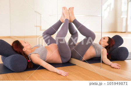 Pregnant woman is engaged in yoga. Bent Candle Pose or Viparita Karani 105949871