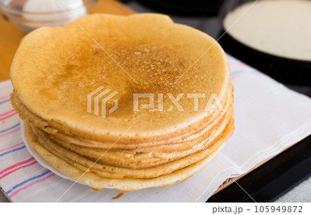 Cooking traditional pancakes from wheat flour in the kitchen 105949872