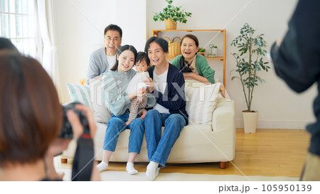 三世代家族を記念撮影をするカメラマン 105950139
