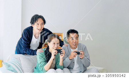 ゲームをするシニア夫婦を見守る若い男性 105950142