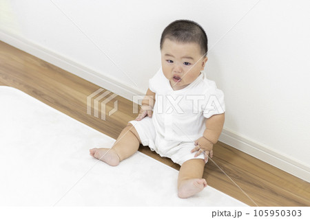 絨毯に座って泣く赤ちゃん（男の子、日本人、生後8か月） 105950303