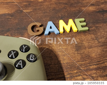 机に置かれたコントローラとGAMEの文字 105950335