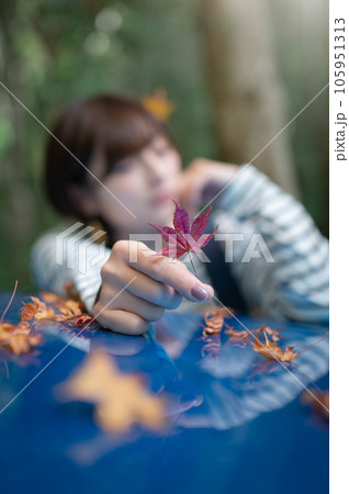 紅葉を一つ摘んで前に出してる女性 紅葉にピント 紅葉を一つ摘んで前に出してる女性 紅葉にピント 105951313