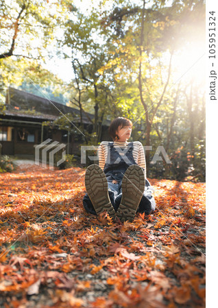 落ち葉の中足の裏のこちらに向けて座ってるアウトドア女子 105951324