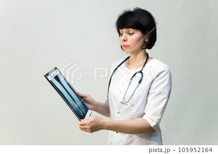 Female nurse examines a picture of a broken leg Female nurse examines a picture of a broken leg 105952164